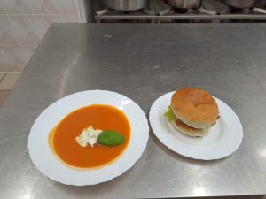 Zupa krem z kleksem ze śmietany oraz fishburger
