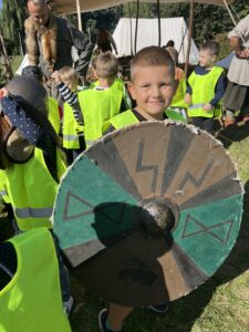 Chłopiec prezentuje tarczę średniowiecznego wikinga.