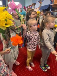 Dzieci machając kolorowymi kwiatami, witają Panią Wiosnę.